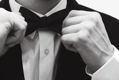 Close-up of man adjusting his bow tie