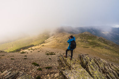 Rear view of man on mountain against sky