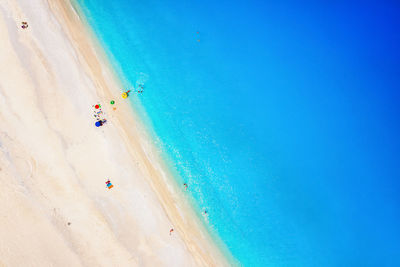 People on beach against blue sky