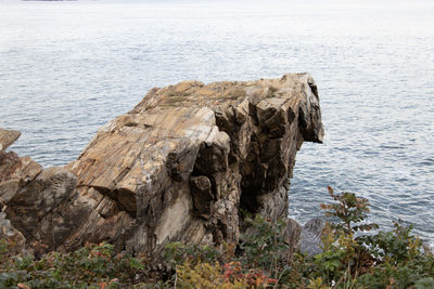 Rock formation in sea against sky
