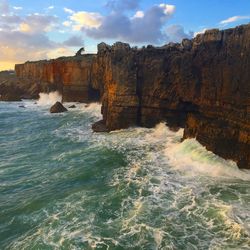 Scenic view of rocks in sea against sky