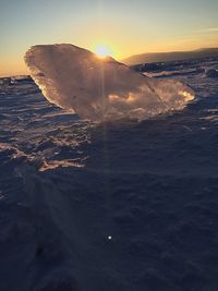 Aerial view of frozen sea against sky during sunset