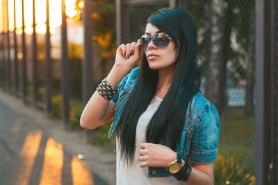 Young woman wearing sunglasses standing outdoors