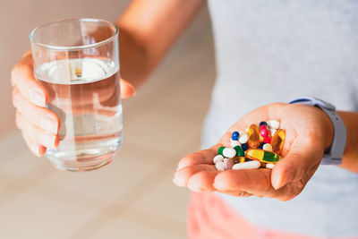 Cropped hand of woman holding pills