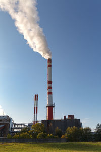 Low angle view of smoke emitting from factory against sky