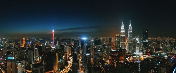 Illuminated cityscape against sky at night