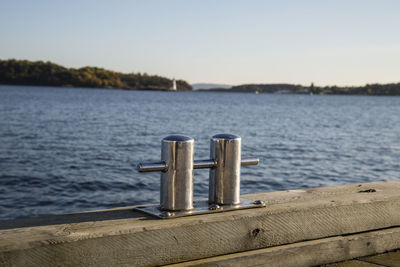 Cleat on wooden railing by lake