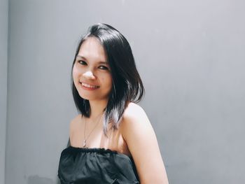 Portrait of smiling young woman against white background