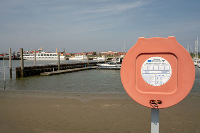 Coin-operated binoculars by sea against sky