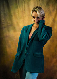 Young woman standing against yellow wall