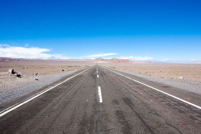 Road amidst landscape against blue sky