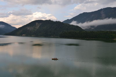 Scenic view of lake by mountains against sky