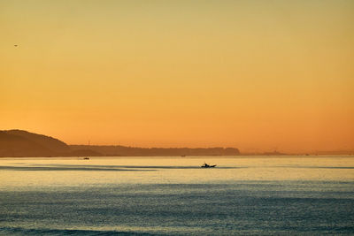 Scenic view of sea against orange sky