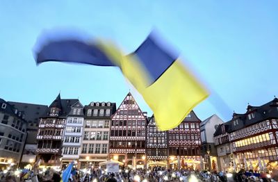 Illuminated city against sky demonstration ukraine with ukraine flag 