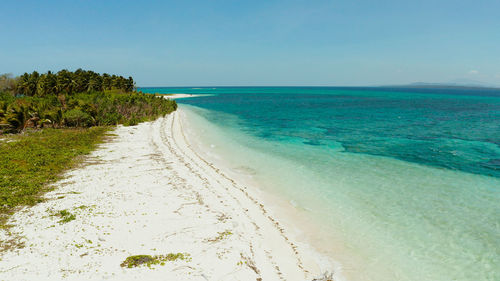 White sandy beach with turquoise water by atoll coral reef and blue sea. small island canimeran 