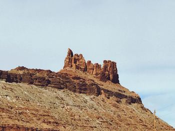 Low angle view of cliff against sky