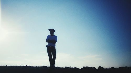 Rear view of silhouette man standing on field against sky
