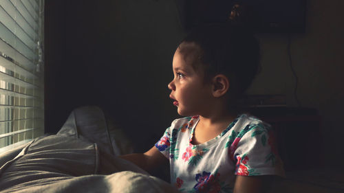 Girl looking away while sitting at home