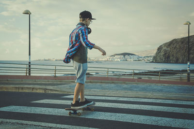 Teenage boys with skateboard on zebra crossing