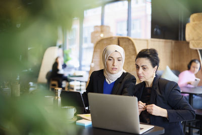 Businesswomen using digital tablet in cafe