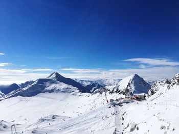 Scenic view of snowcapped mountains against blue sky