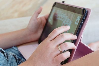 Midsection of woman playing poker in digital tablet