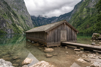 Gazebo on rock by lake against sky