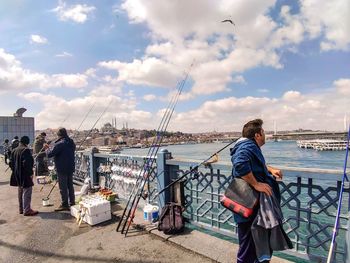 People standing by sea against sky