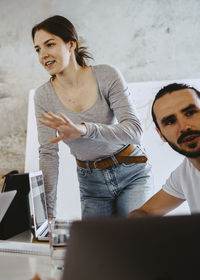 Female hacker discussing with colleagues in meeting at office