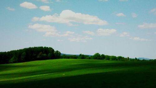 Scenic view of golf course against sky