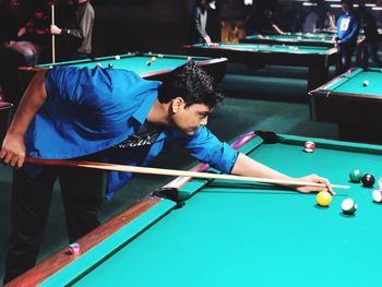 High angle view of young man playing pool ball