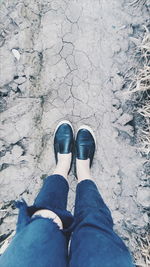 Low section of man standing on dirt road