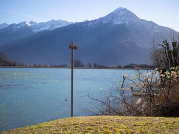Scenic view of lake by snowcapped mountains against sky