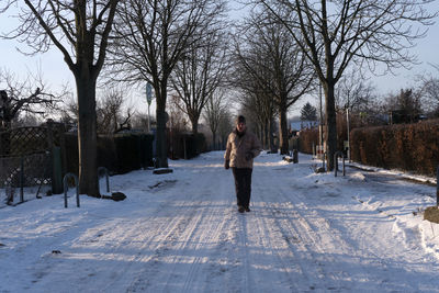 Man standing on snow covered footpath