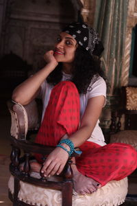 Portrait of young woman sitting on chair