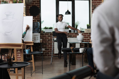 Rear view of man using mobile phone in cafe