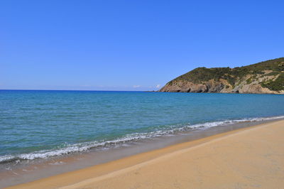 View of calm beach against blue sky