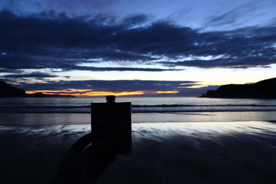 Silhouette of beach against sky during sunset