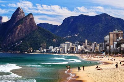 Mountains by beach against sky