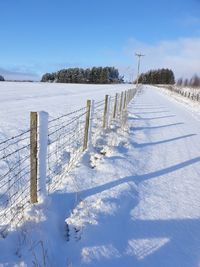 Scenic view of snow covered field against sky