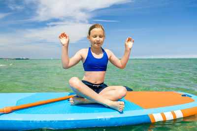 Full length of woman smiling against sea