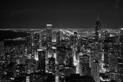 Illuminated cityscape against sky at night