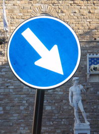 Arrow sign against blue sky