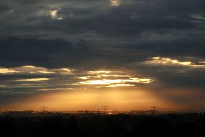 Silhouette cityscape against sky during sunset