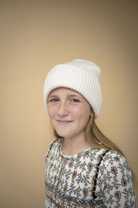 Portrait of young woman wearing hat against pink background