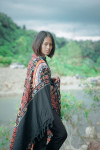 Portrait of smiling woman standing against water