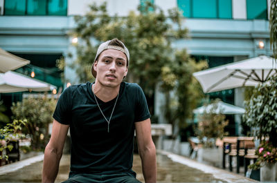 Portrait of young man looking away in city