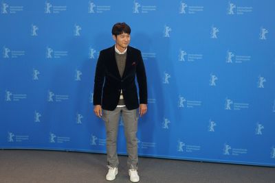 Full length of a young man standing against blue wall