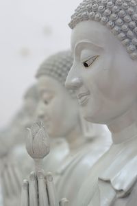 Close-up of buddha statue against building