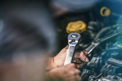 Close-up of man repairing engine